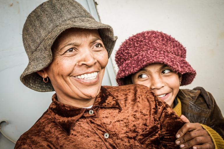 Malagasy woman and her daughter behind her smiling