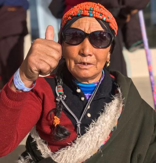 Tibetan Woman Wearing Traditional Jewelry and Clothing Giving Thumbs Up