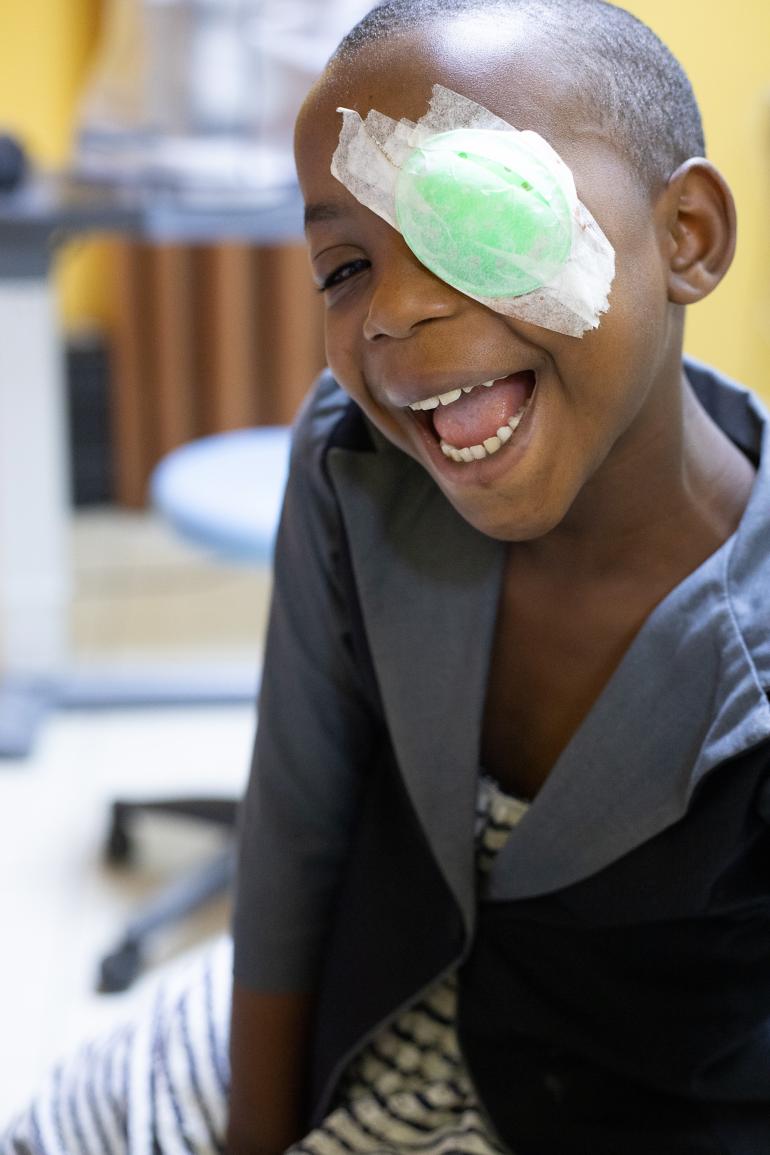 Yvette a girl from Burundi  smiling with an eye patch by Jean de Diieu