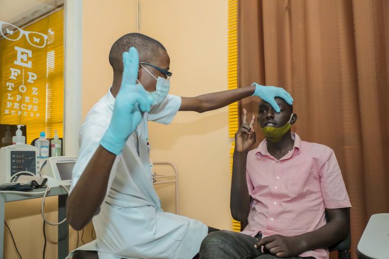 Thierry in Burundi visual acuity test with nurse