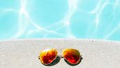 pair of Amevie sunglasses on ground next to pool