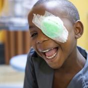 Yvette in Burundi smiling wearing her eye patch after surgery