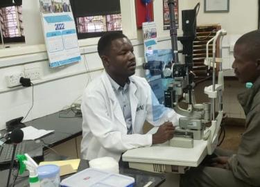 Dr. Camillus Mbaga examining a patient 