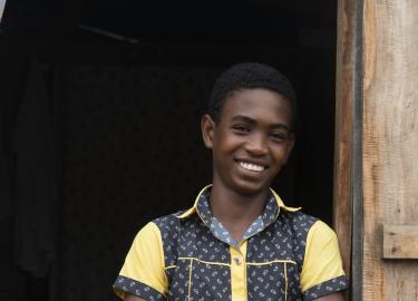 Banner 15-yr-old Jaonah leaning against the doorway of his home in Sambava Madagascar