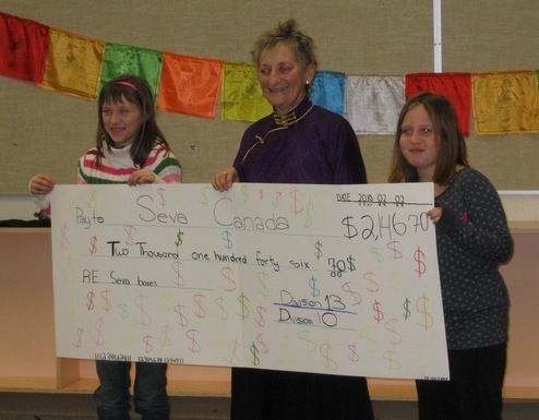 Two of the students at Tomekichi Homma School presenting a cheque to Susan Erdmann