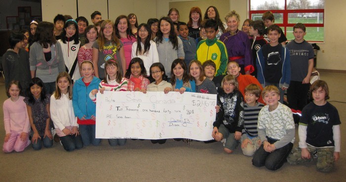 Students of Mme Grunfeld and Mme Lee with cheque for Seva Canada