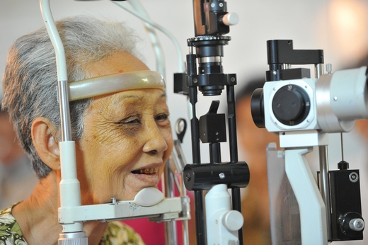 elderly Cambodian woman having eyes examined 