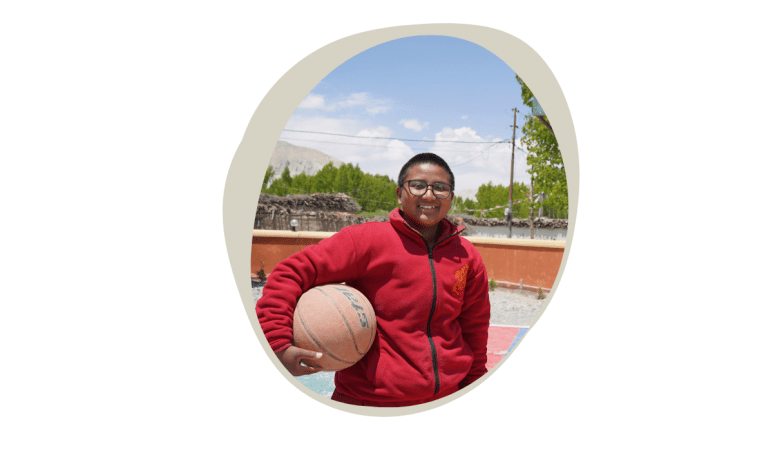 Nepali tean with basketball posing in front of hoop
